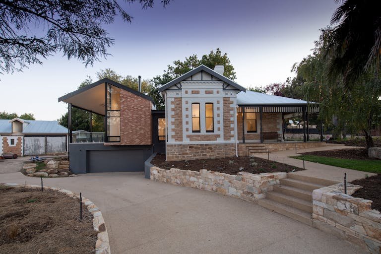 Contemporary cottage with brick and stone facade in a serene setting.